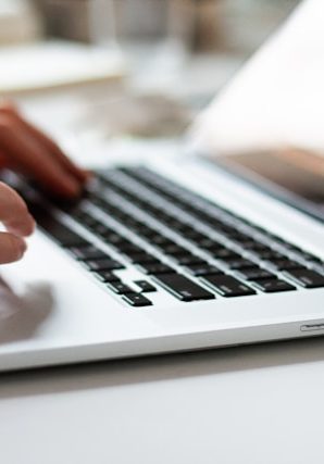 Hands typing on laptop keyboard at desk